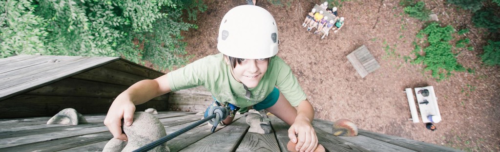 kids climbing wall at outdoor camp